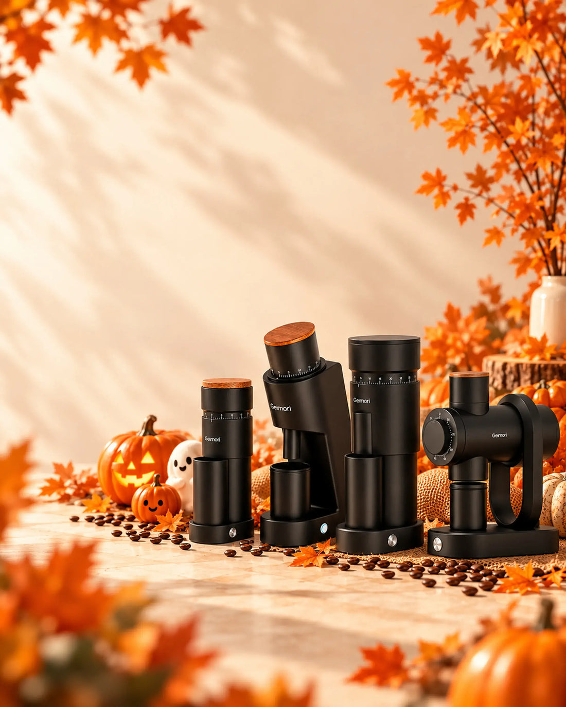 Four black coffee grinders arranged on a tabletop with autumn leaves, pumpkins, and warm sunlight in the background.slider_item_re4TfX