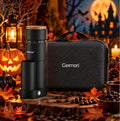A Geimori coffee grinder and matching carrying case displayed together in a Halloween-themed setting with pumpkins, candles, autumn leaves, and a haunted-house background.