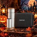 A Geimori portable coffee maker with a brushed silver body and wooden accents stands next to its dark gray carrying case on a rustic wooden surface. The scene is styled for Halloween with pumpkins, candles, autumn leaves, coffee beans, and a haunted house backdrop under a full moon.