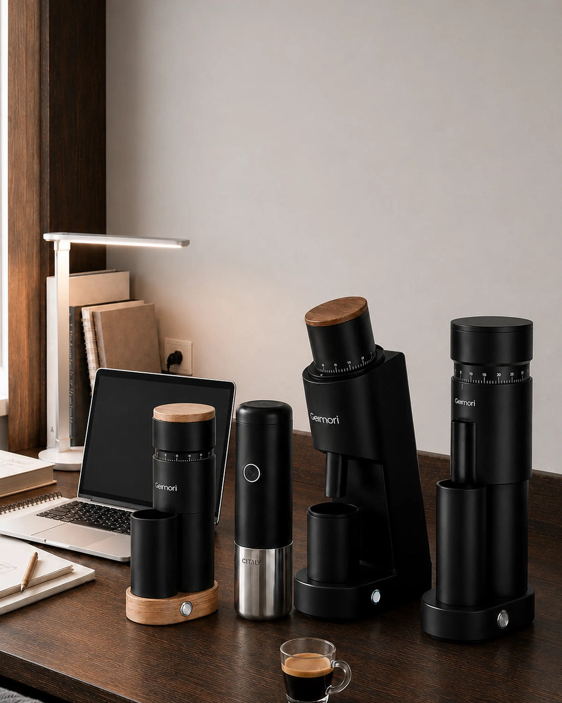 A set of black Mennip coffee brewing and grinding devices arranged on a wooden desk in a home office setting, alongside a laptop, lamp, and espresso cup.slider_item_TC6Wcc